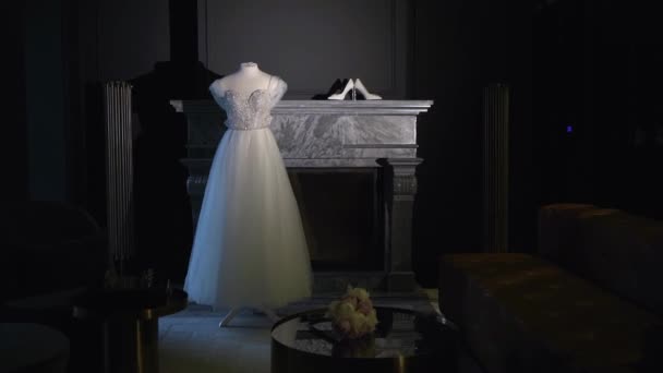 Wedding dress, white bridal gown and shoes on high heels hanging. Morning bride. — Video