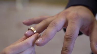 Gelin ve damat törende alyanslarını değiş tokuş ederler. Parmak mücevher yüzüğünü tak..