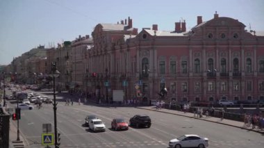 Cars and buses driving along the road. Nevsky avenue and Anichkov bridge.