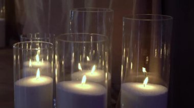 Şeffaf cam şişelerde fitilleri olan dekoratif beyaz mumlar..