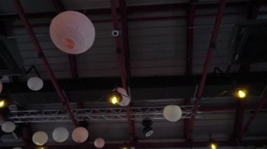 Round paper balls, lanterns hang from the ceiling. White and pink for holiday.