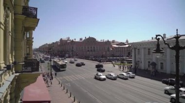 Cars and buses driving along the road. Nevsky avenue and Anichkov bridge.
