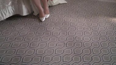 Gelin, topuklu beyaz düğün ayakkabısı giyer. Gelinlikli kız giyiniyor..