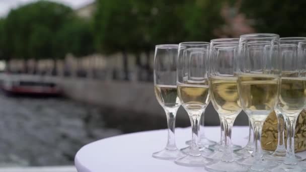 Glasses filled with champagne or white sparkling wine. Sailing yacht, boa, ship. — Stock video