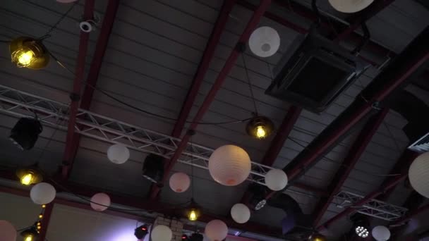 Round paper balls, lanterns hang from the ceiling. White and pink for holiday. — Vídeo de Stock