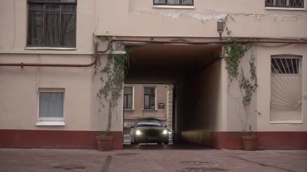 White luxury sedan Jaguar XJ long car drive in yard of residential building in a city. — Vídeo de Stock