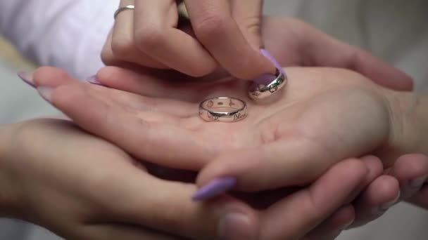 Молодая влюбленная пара держит обручальные кольца в руках. — стоковое видео