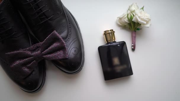Мужская черная кожа классические туфли, галстук-бабочка и духи. Аксессуары для жениха. — стоковое видео