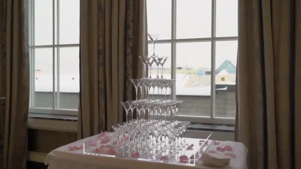 Pyramidová věž z prázdných sklenic na alkoholické nápoje šampaňské. — Stock video