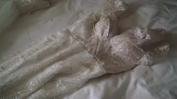 Rochie de mireasă albă așezată pe lenjerie de pat în dormitor. Rochie de mireasă. — Videoclip de stoc