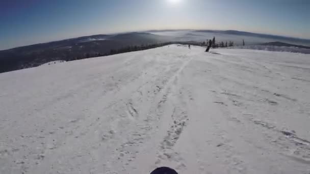 Osoba snowboarding ze zasněženého svahu. snowboardista na palubě jezdí na horách. — Stock video
