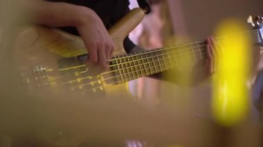 Gitar çalan gitarist müzisyen. Sahnede telli müzik aletleri.