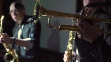 Sahnede rüzgar enstrümanlı orkestra. Konserde müzik çalan grup..