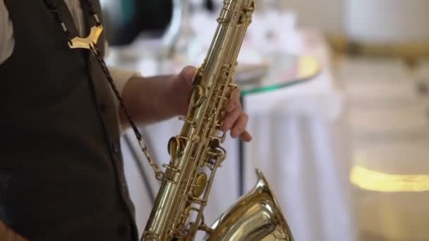 Saksofonista grający na saksofonie na przyjęciu. Człowiek ze złotym saksofonistą. — Wideo stockowe