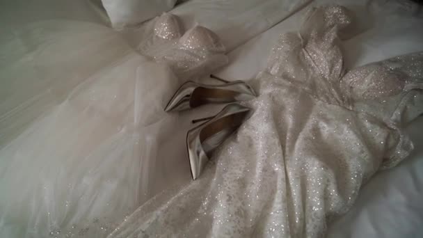 Rochie de mireasă albă așezată pe lenjerie de pat în dormitor. Rochie de mireasă. — Videoclip de stoc