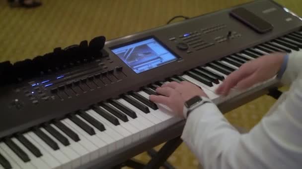 The pianist at the party plays music on the piano. Man in a white suit — Stock Video