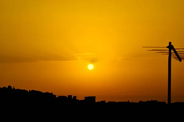 右側にアンテナのシルエットとオレンジの黄色の夕日 — ストック写真