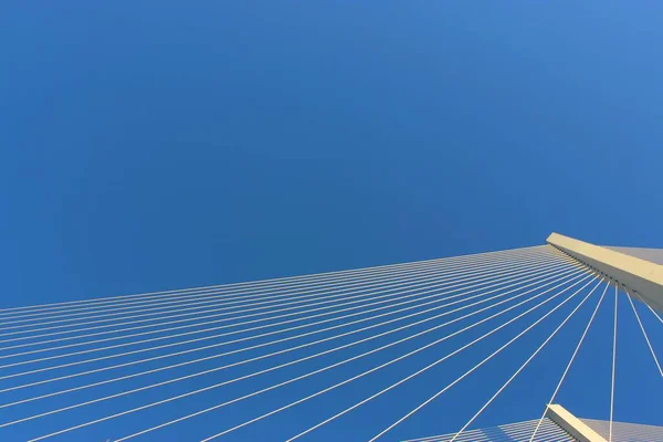 Vista del puente contra el cielo azul. Los cables y los altos pilones de este largo puente de carretera. Materiales de acero y hormigón para esta estructura de transporte. Puente colgante más grande Cruce —  Fotos de Stock