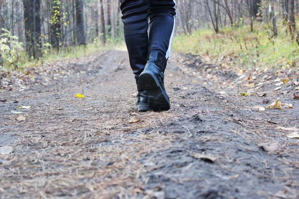 Wandelen of hardlopen met je voeten op het pad, Wandelen in de herfst op de weg in een afgelegen herfstbos met gevallen gele bladeren. Groene concepten. Reizigers lopen. ruimte voor het schrijven van tekst op een — Stockfoto
