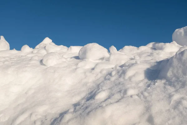 Neve fofa que jaz em colina e céu azul em volta, depois da nevasca pesada. Snowdrifts com céu azul para cartaz, calendário, post, protetor de tela, papel de parede, cartão postal, cartão, banner, capa, cabeçalho — Fotografia de Stock