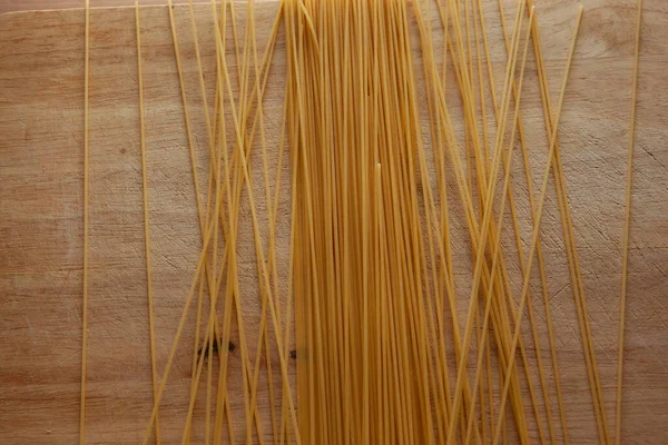 Pasta Spaghetti Een Houten Plank Italiaanse Pasta Gele Spaghetti Verspreid — Stockfoto