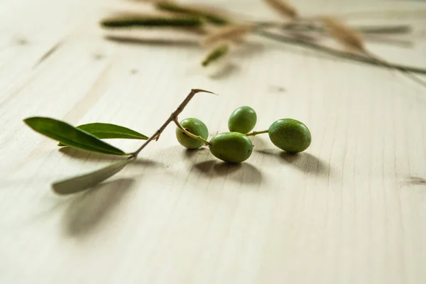 Branch with olives on wood table background, Concept and idea of food cook rustic still. Green olives with leaves for publication, poster, screensaver, wallpaper, postcard, banner, cover, post — Stock Photo, Image