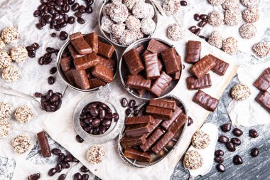 Tahta arka planda çeşitli çikolatalı şekerler. Çikolatalı şekerler. Tatlı arkaplanı.