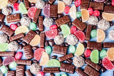 Tahta arka planda çeşitli çikolatalı şekerler. Çikolatalı şekerler. Tatlı arkaplanı.