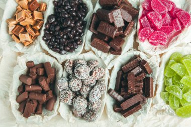 Tahta arka planda çeşitli çikolatalı şekerler. Çikolatalı şekerler. Tatlı arkaplanı.