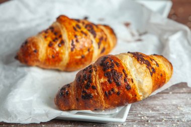 Ahşap zemin üzerinde taze pişmiş kruvasanlar..