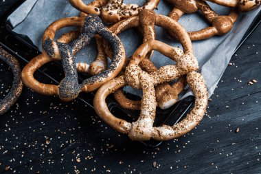 Taze ev yapımı yumuşak krakerler. Siyah arka planda tohumları olan farklı türde kraker..