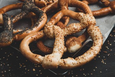 Taze ev yapımı yumuşak krakerler. Siyah arka planda tohumları olan farklı türde kraker..