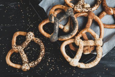 Taze ev yapımı yumuşak krakerler. Siyah arka planda tohumları olan farklı türde kraker..