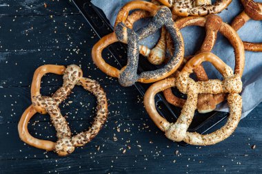 Taze ev yapımı yumuşak krakerler. Siyah arka planda tohumları olan farklı türde kraker..