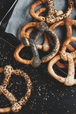 Taze ev yapımı yumuşak krakerler. Siyah arka planda tohumları olan farklı türde kraker..