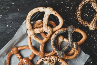 Taze ev yapımı yumuşak krakerler. Siyah arka planda tohumları olan farklı türde kraker..