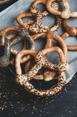 Taze ev yapımı yumuşak krakerler. Siyah arka planda tohumları olan farklı türde kraker..