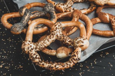 Taze ev yapımı yumuşak krakerler. Siyah arka planda tohumları olan farklı türde kraker..