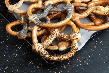 Taze ev yapımı yumuşak krakerler. Siyah arka planda tohumları olan farklı türde kraker..