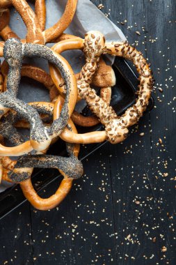 Taze ev yapımı yumuşak krakerler. Siyah arka planda tohumları olan farklı türde kraker..