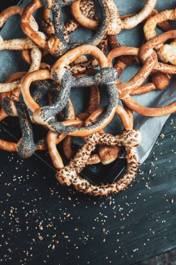 Taze ev yapımı yumuşak krakerler. Siyah arka planda tohumları olan farklı türde kraker..