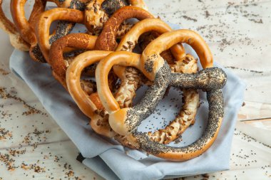 Taze ev yapımı yumuşak krakerler. Siyah arka planda tohumları olan farklı pişmiş simit türleri..