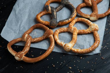 Taze ev yapımı yumuşak krakerler. Ahşap arka planda tohumları olan farklı türde fırınlanmış simit..