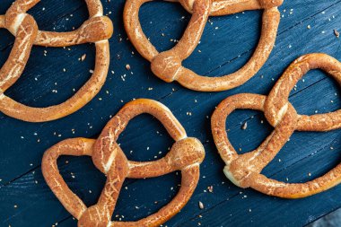 Taze ev yapımı yumuşak krakerler. Siyah arka planda tohumları olan farklı pişmiş simit türleri..