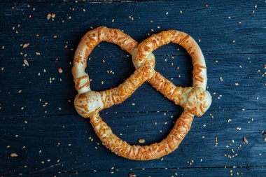 Taze ev yapımı yumuşak krakerler. Siyah arka planda tohumları olan farklı pişmiş simit türleri..