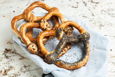 Taze ev yapımı yumuşak krakerler. Siyah arka planda tohumları olan farklı pişmiş simit türleri..