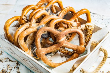 Taze ev yapımı yumuşak krakerler. Siyah arka planda tohumları olan farklı pişmiş simit türleri..