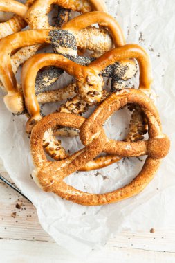 Taze ev yapımı yumuşak krakerler. Siyah arka planda tohumları olan farklı pişmiş simit türleri..