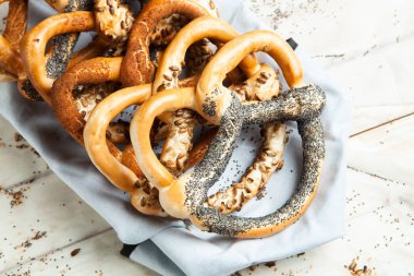 Taze ev yapımı yumuşak krakerler. Siyah arka planda tohumları olan farklı pişmiş simit türleri..