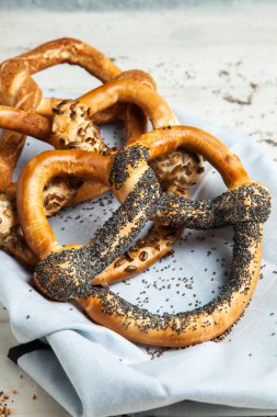 Taze ev yapımı yumuşak krakerler. Siyah arka planda tohumları olan farklı pişmiş simit türleri..